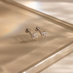 Pair of silver flatback earrings with vintage-inspired square diamond design on white marble.