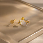 Set of gold flatback earrings shown apart—post, backing, and diamond Art Deco head on glossy surface.