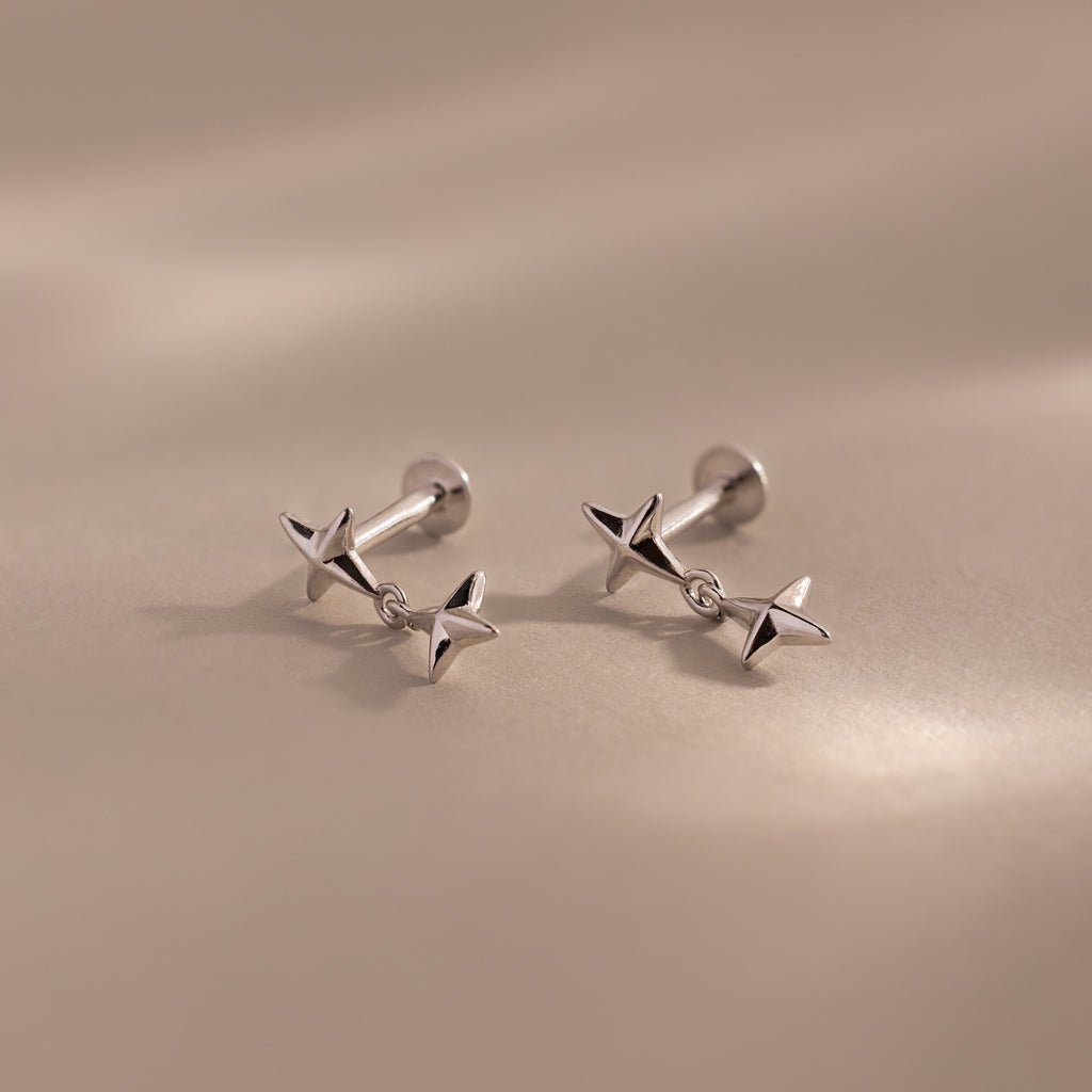 Pair of silver star drop flatback studs shown on a neutral background.
