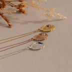 The Organic Fingerprint Multi Birthstone Necklace features textured metal pendants in gold, rose gold, and silver on chains—ideal as a personalized keepsake or unique family necklace.