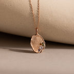 The Organic Fingerprint Multi Birthstone Necklace in Rose Gold is displayed against a beige background—a stunning personalized necklace perfect as a birthstone keepsake.
