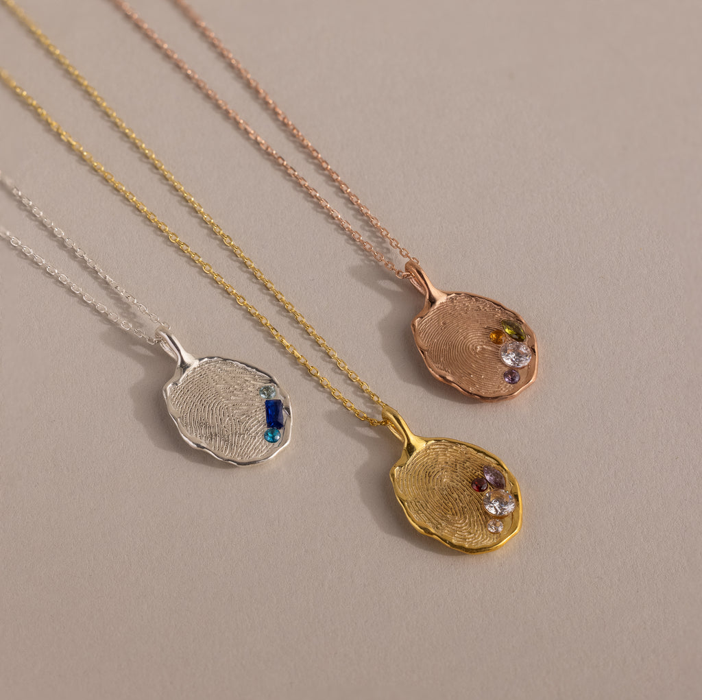 The Organic Fingerprint Multi Birthstone Necklace in Rose Gold features a unique fingerprint-shaped pendant with colorful gemstones—perfect as personalized jewelry or a custom birthstone necklace.