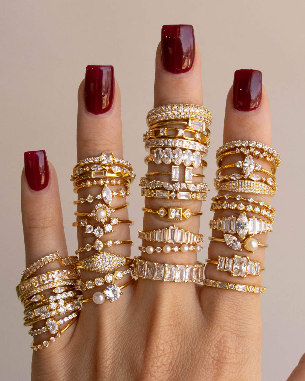 Ring feature photo of a jewelry model’s hand showcasing multiple diamond rings on each finger.