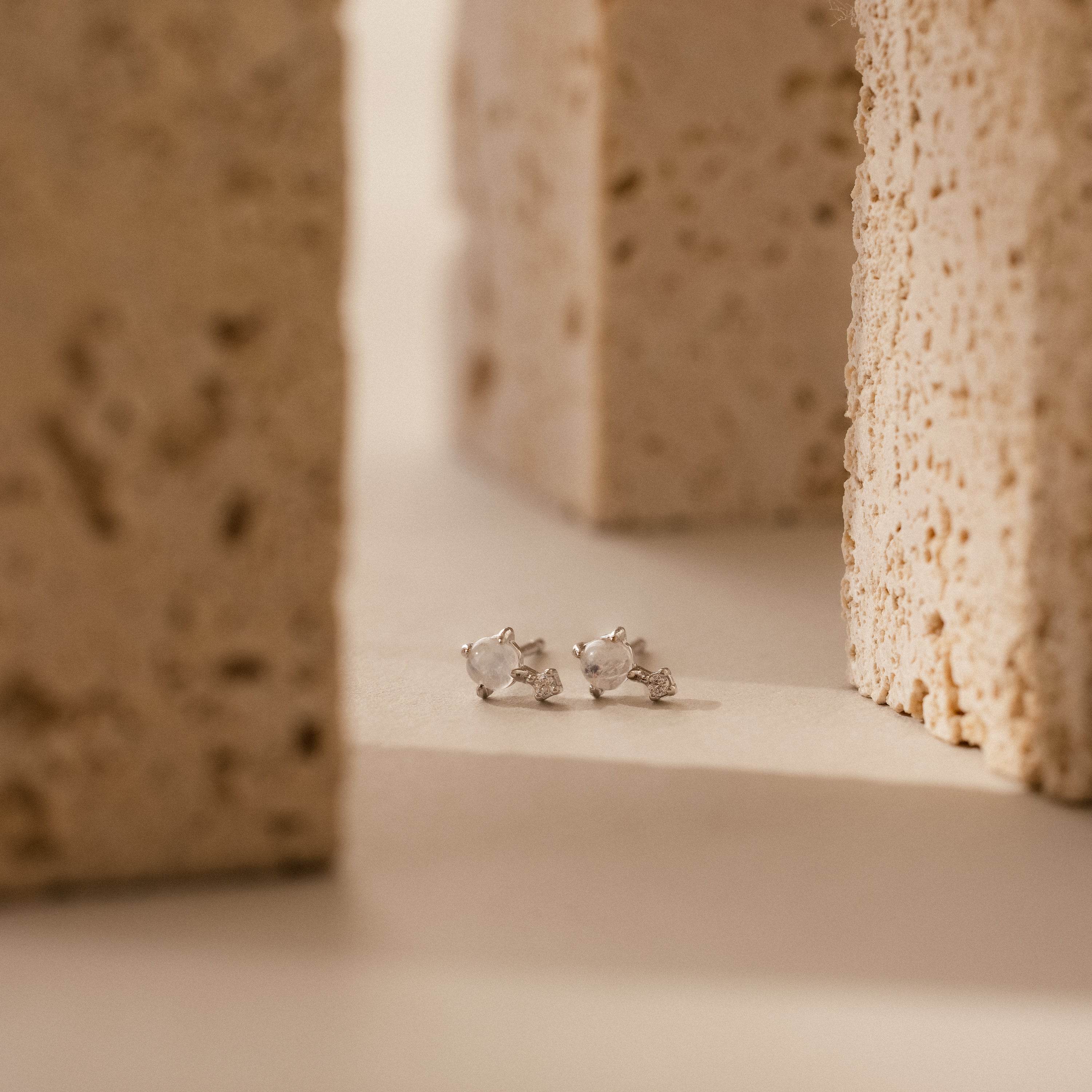 Moonstone Orbit Studs in Sterling Silver, featuring clear gemstones between two textured beige stone blocks—perfect for those who appreciate the timeless elegance of diamond accent earrings.