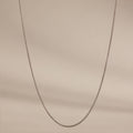 A delicate Woven Chain Necklace in Sterling Silver showcased against a soft beige background.