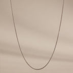 A delicate Woven Chain Necklace in Sterling Silver showcased against a soft beige background.