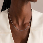 A person wearing the Woven Chain Necklace in Sterling Silver with a cream-colored top.