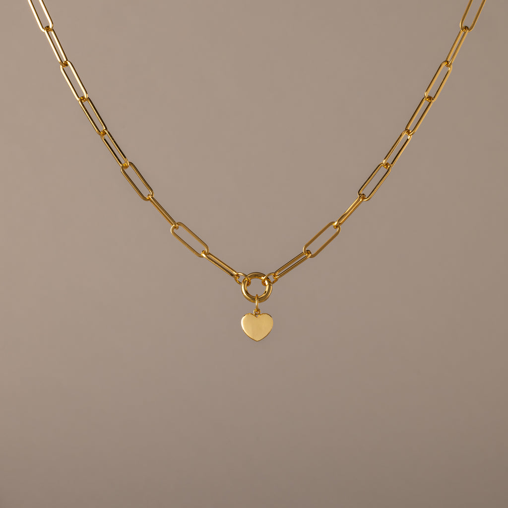Paperclip Heart Charm Necklace in 18K Gold with elongated links and a delicate heart pendant, displayed on a neutral background—the perfect accessory for subtle elegance with any outfit.