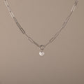 The Paperclip Heart Charm Necklace in Silver features elongated links and a small heart-shaped pendant—a delicate accessory perfect for everyday wear.