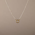 Pearl Chain Clasp Necklace in 18K Gold, featuring a gold circular pendant and shown on a beige background—a timeless piece for any jewelry collection.