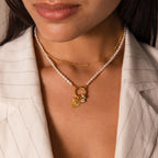 Woman in a pinstriped blazer layered with gold jewelry, featuring our stunning Pearl Chain Clasp Necklace in 18K Gold.