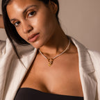 Woman in a pinstripe blazer wears the Pearl Chain Clasp Necklace in 18K Gold, gazing at the camera with a neutral expression—a sophisticated piece to elevate any jewelry collection.