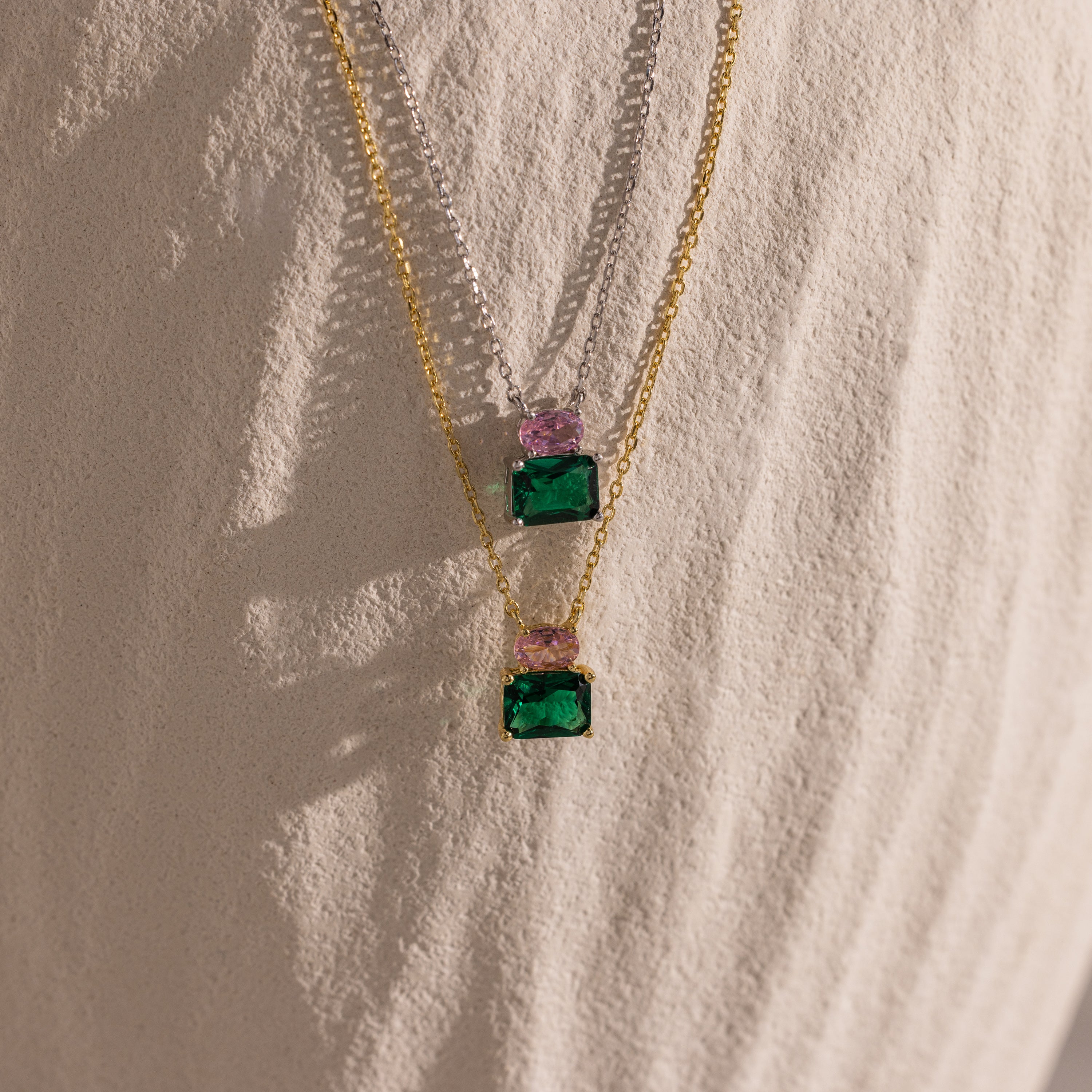 Flatlay of our Emerald Bloom Necklace in Silver and Gold finish