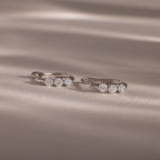 Flatlay of our Lace Diamond Hoops in Sterling Silver on a beige fabric background