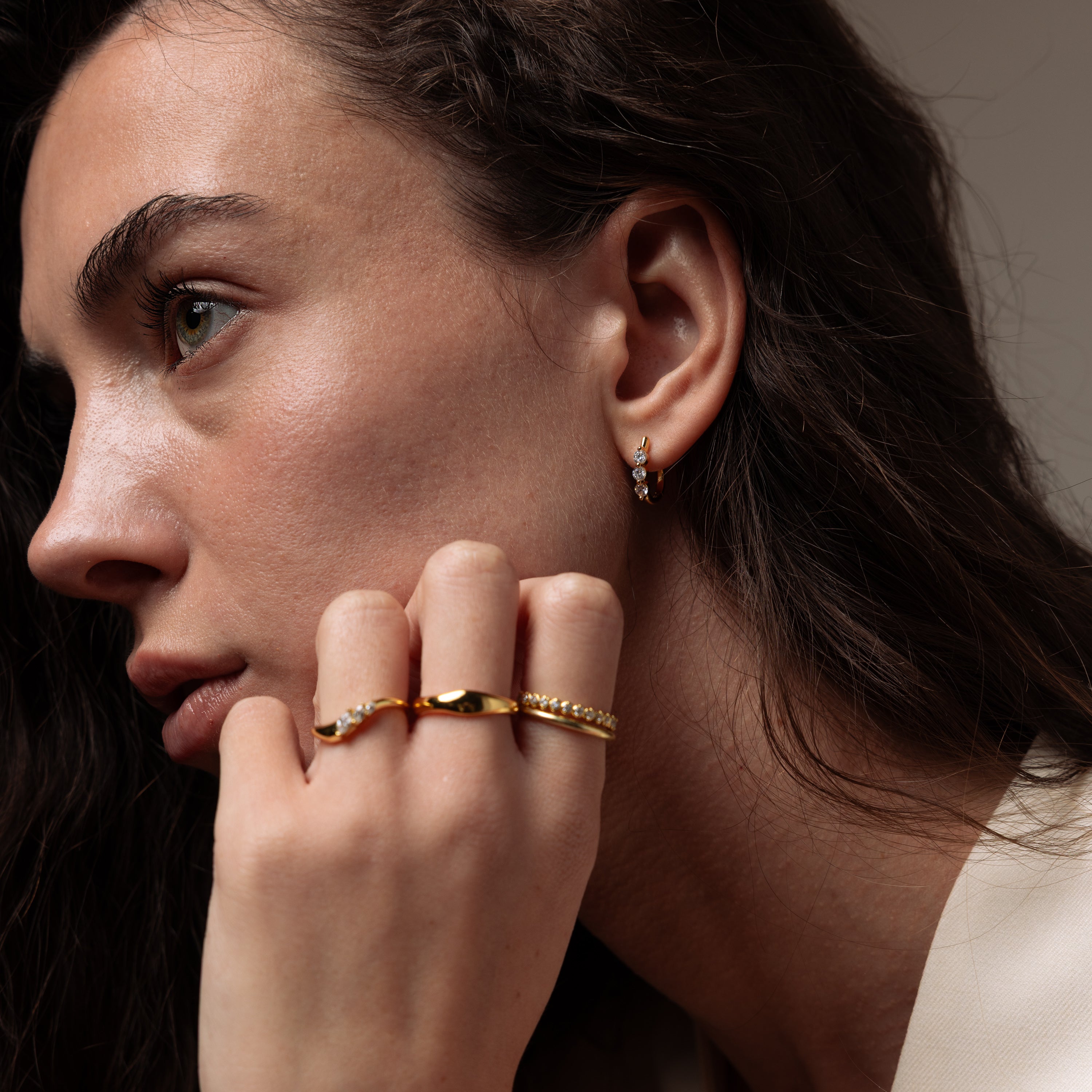 Close-up of a model wearing our Lace Diamond Hoops in Gold, styled with an ring stack