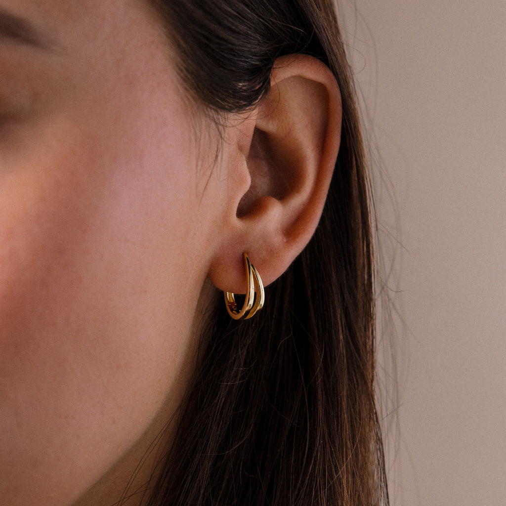 Close-up of a model wearing our Oval Duo Hoops in Gold