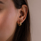 Close-up of a model wearing our Oval Duo Hoops in Gold