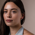 Faraway shot of a model wearing our Tiny Teardrop Huggies in White Gold