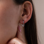 Close up of a model wearing our Tiny Teardrop Huggies in White Gold