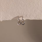 Flatlay of our Tiny Teardrop Huggies in White Gold