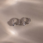 Close up flatlay of our Tiny Teardrop Huggies in White Gold