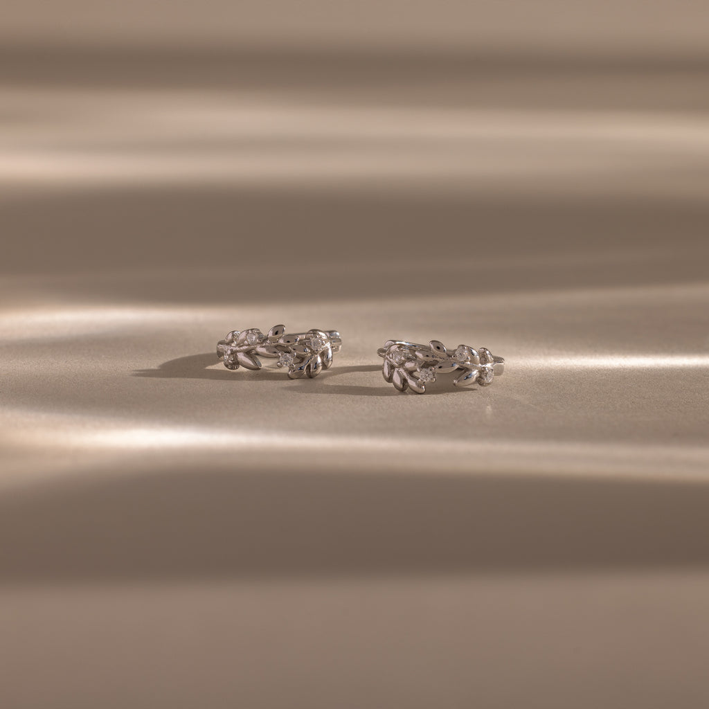 Close up flatlay image of our Diamond Leaf Hoops in Silver