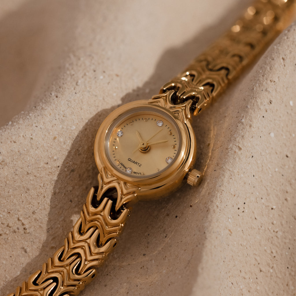 Close up of our Wavy Link Timepiece watch on a beige surface