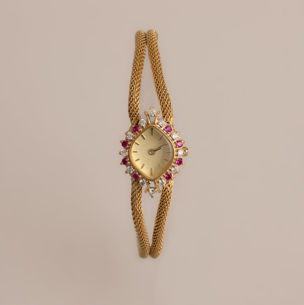 Our Duo Chain Ruby Timepiece watch on a beige background
