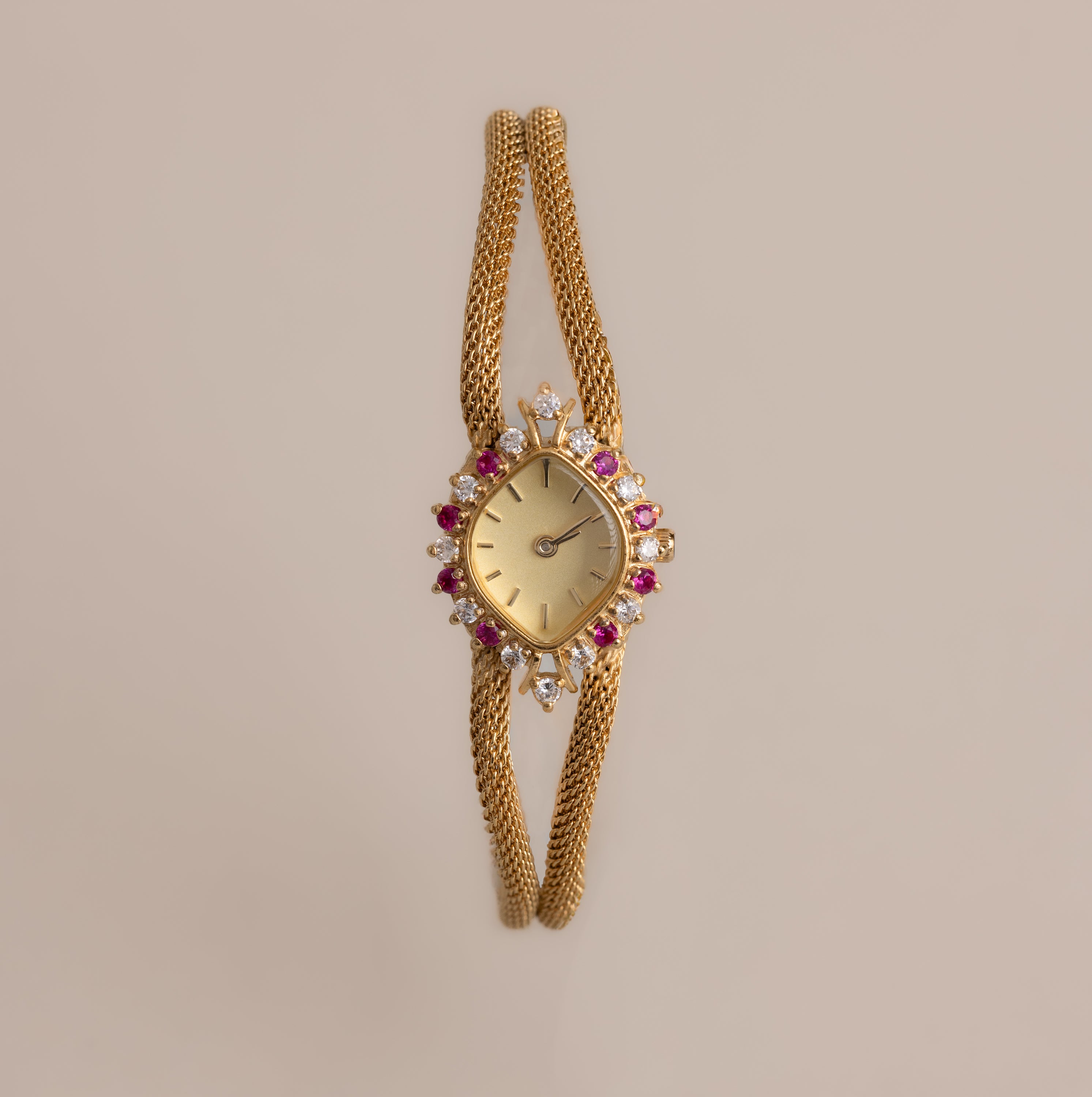 Our Duo Chain Ruby Timepiece watch on a beige background