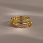 The Triple Linked Pink Tourmaline Ring Set features three gold rings, including two with pink tourmaline gemstones, elegantly stacked for a timeless and delicate look.