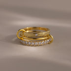 The Triple Linked Diamond Ring Set, featuring a statement ring with a row of small diamonds and a plain band with a single diamond, is displayed elegantly on a neutral background.
