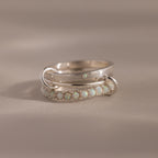 The Triple Linked Opal Ring Set features silver bands adorned with small opal stones, shown on a neutral background.