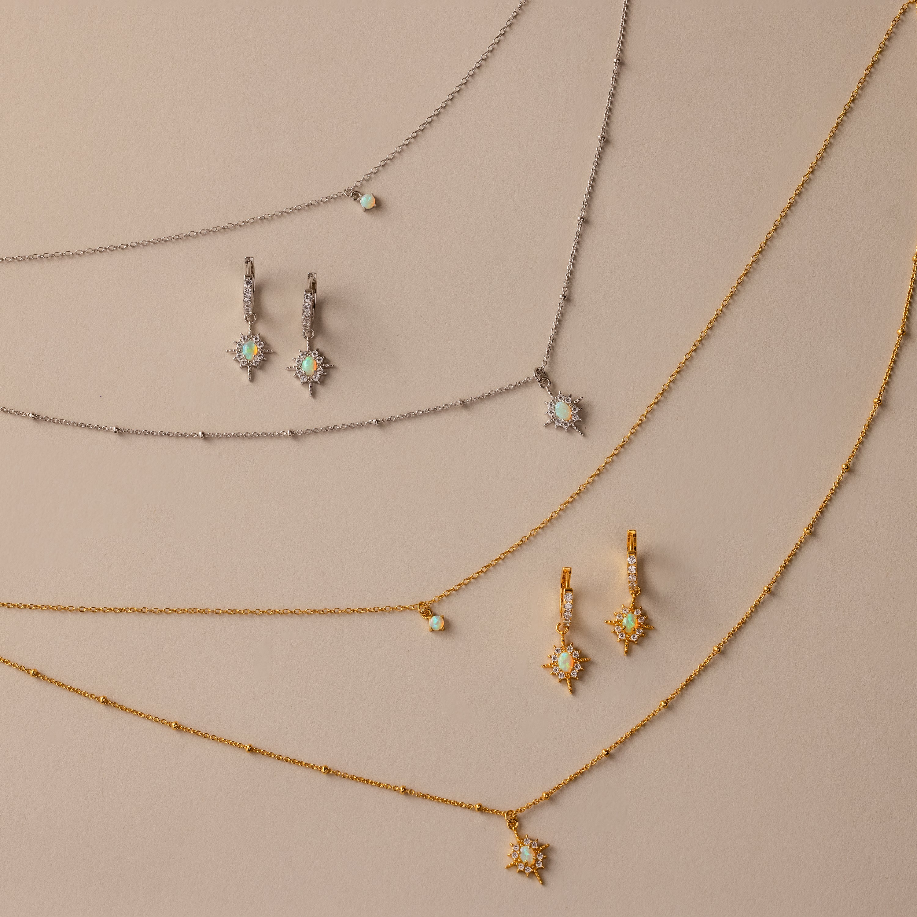 The Opal Star Necklace & Earrings Set in Silver is displayed on a beige background.