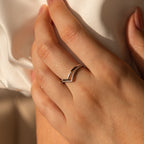 Close-up of a hand with nude nails wearing the Curve Stacking Set in Silver—two thin, delicate silver bands with small diamonds—on the ring finger.