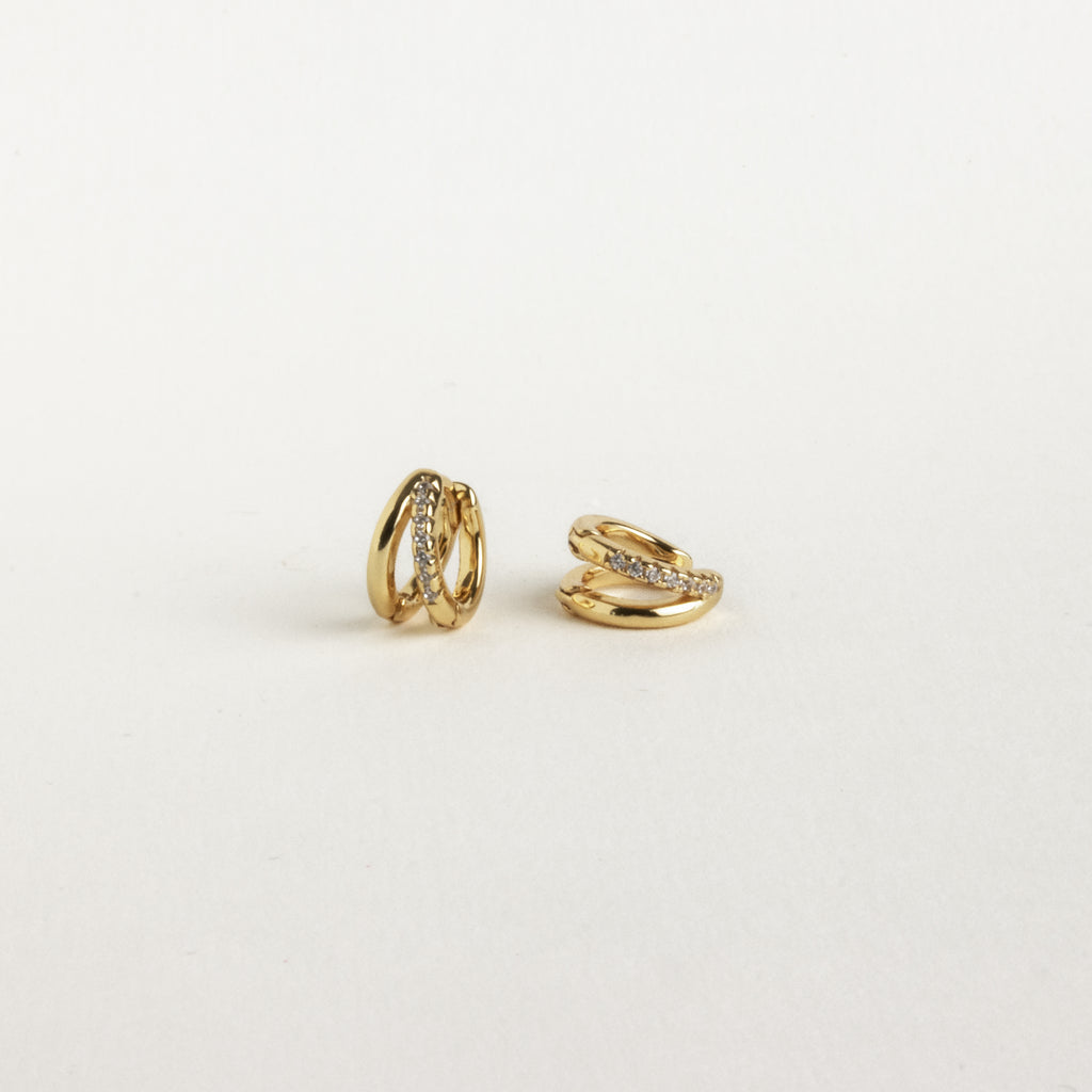Two small gold Amelia Duo Huggies featuring embedded clear stones and pave accents, shown on a plain white background.