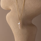 Baroque Pearl Cross Necklace in 18K Gold displayed on a beige textured mannequin bust.