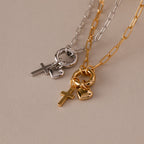 The Cross & Heart Charm Bracelet, featuring elegant gold and silver tones with cross and heart pendants, captures the timeless style of minimalist accessories on a chic beige background.