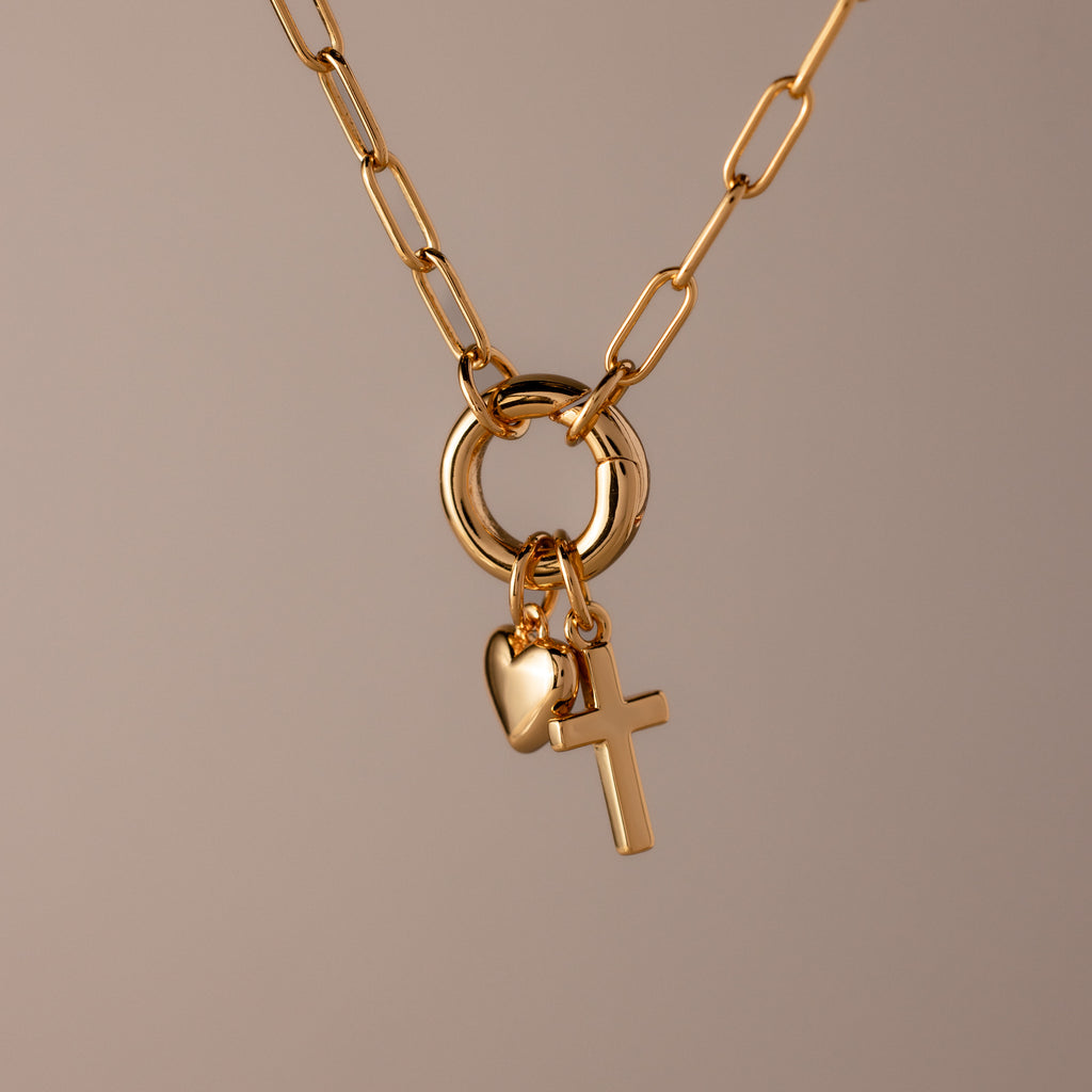 Cross & Heart Charm Bracelet in 18K Gold shown on a neutral background, featuring cross and heart charms that evoke an elegant, timeless style.