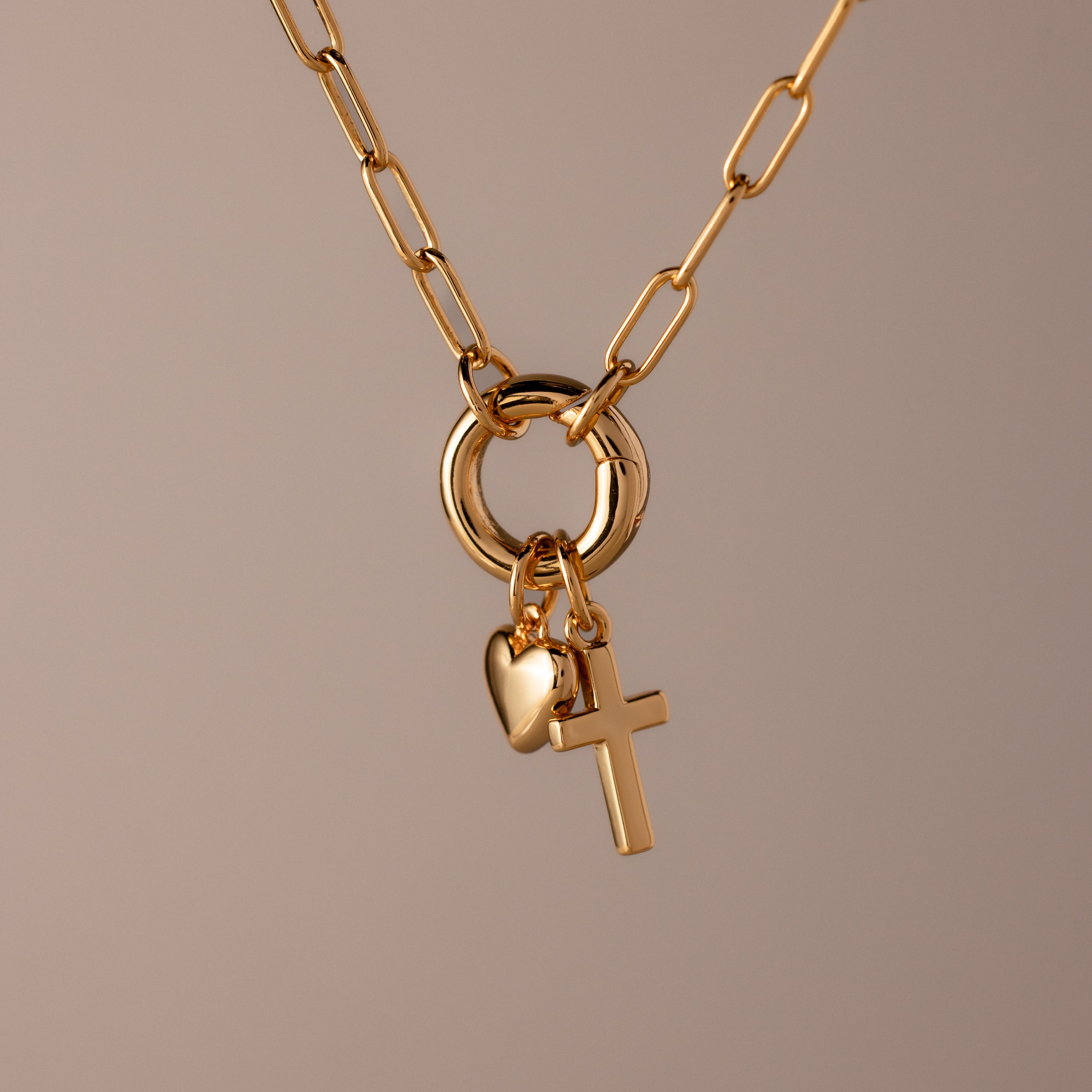 Cross & Heart Charm Bracelet in 18K Gold shown on a neutral background, featuring cross and heart charms that evoke an elegant, timeless style.