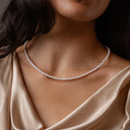 A woman showcases the Summer Pearl Beaded Necklace in Sterling Silver, paired with a champagne satin top that highlights her neck and collarbone.