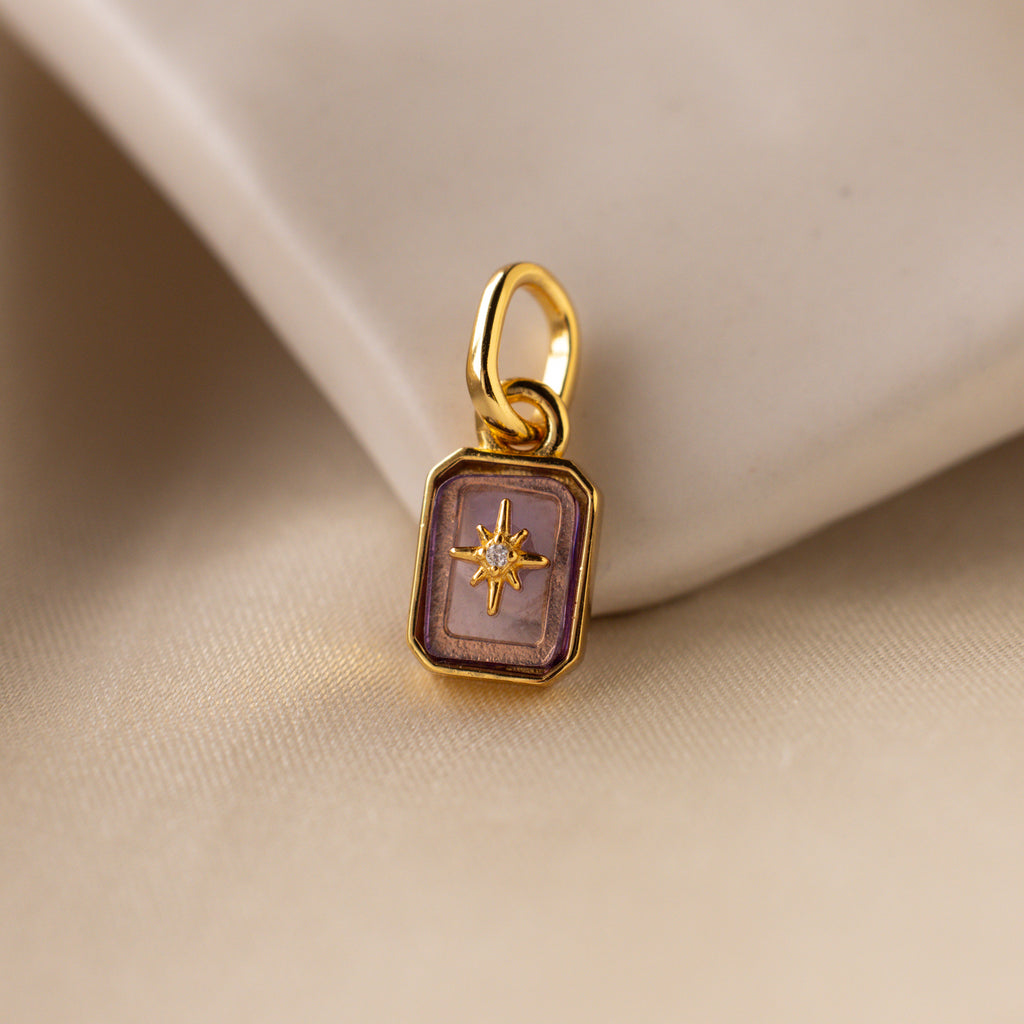 Up close of a light purple alexandrite north star charm with a pavé CZ diamond in the center.