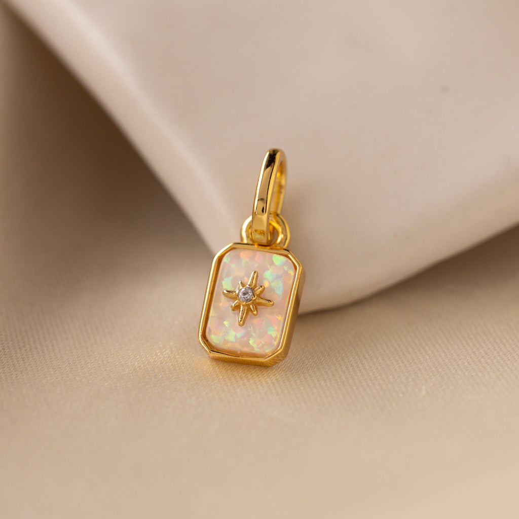 Up close of an iridescent opal north star charm with a delicate pavé diamond in the center.