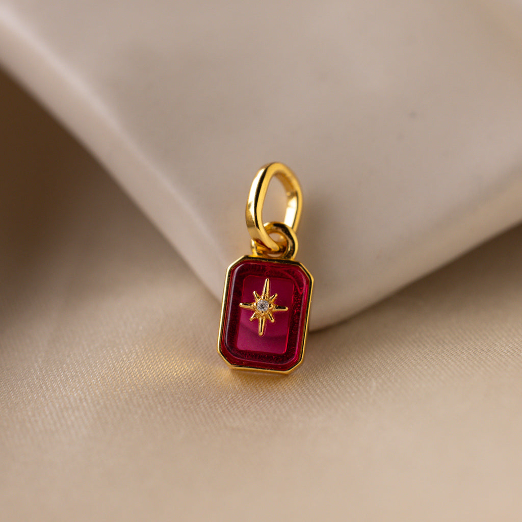 Up close of a pink ruby north star charm with a delicate pavé diamond in the center.