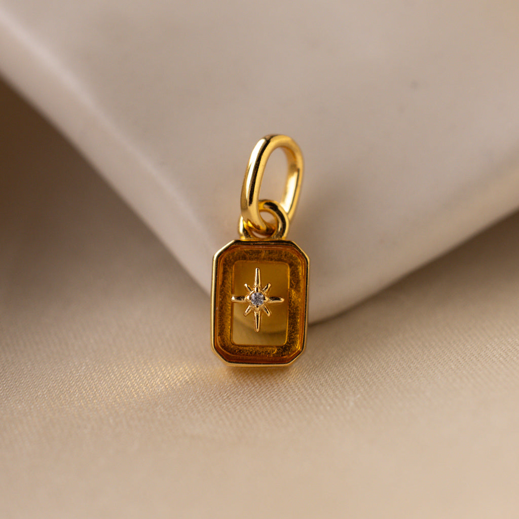 Up close of a yellow topaz north star charm with a pavé CZ diamond in the center.
