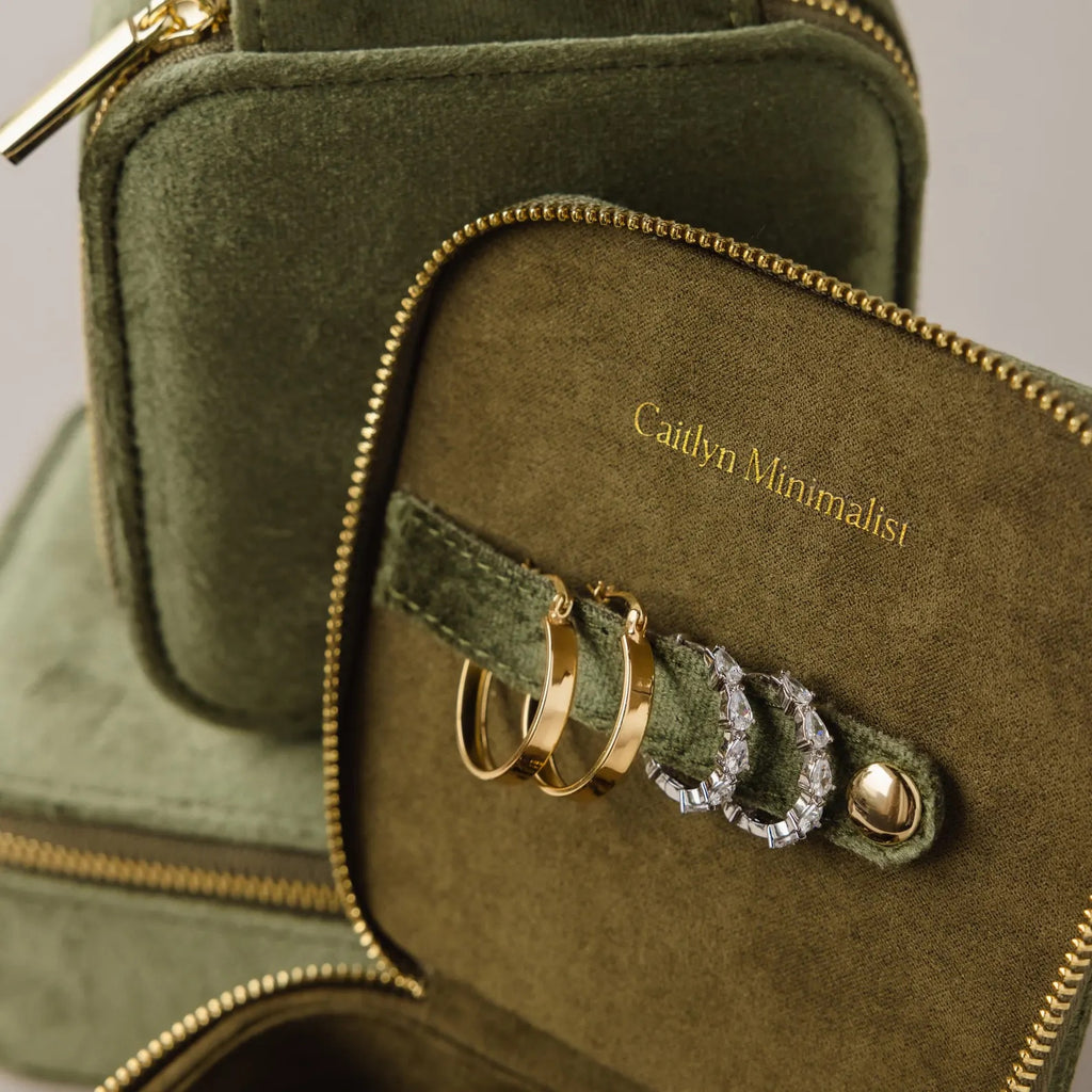 The Green Velvet Jewelry Box offers elegant storage for gold and silver hoop earrings, features "Caitlyn Minimalist" in gold text, and is ideal as a chic travel jewelry organizer.