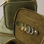 The Green Velvet Jewelry Box offers elegant storage for gold and silver hoop earrings, features "Caitlyn Minimalist" in gold text, and is ideal as a chic travel jewelry organizer.