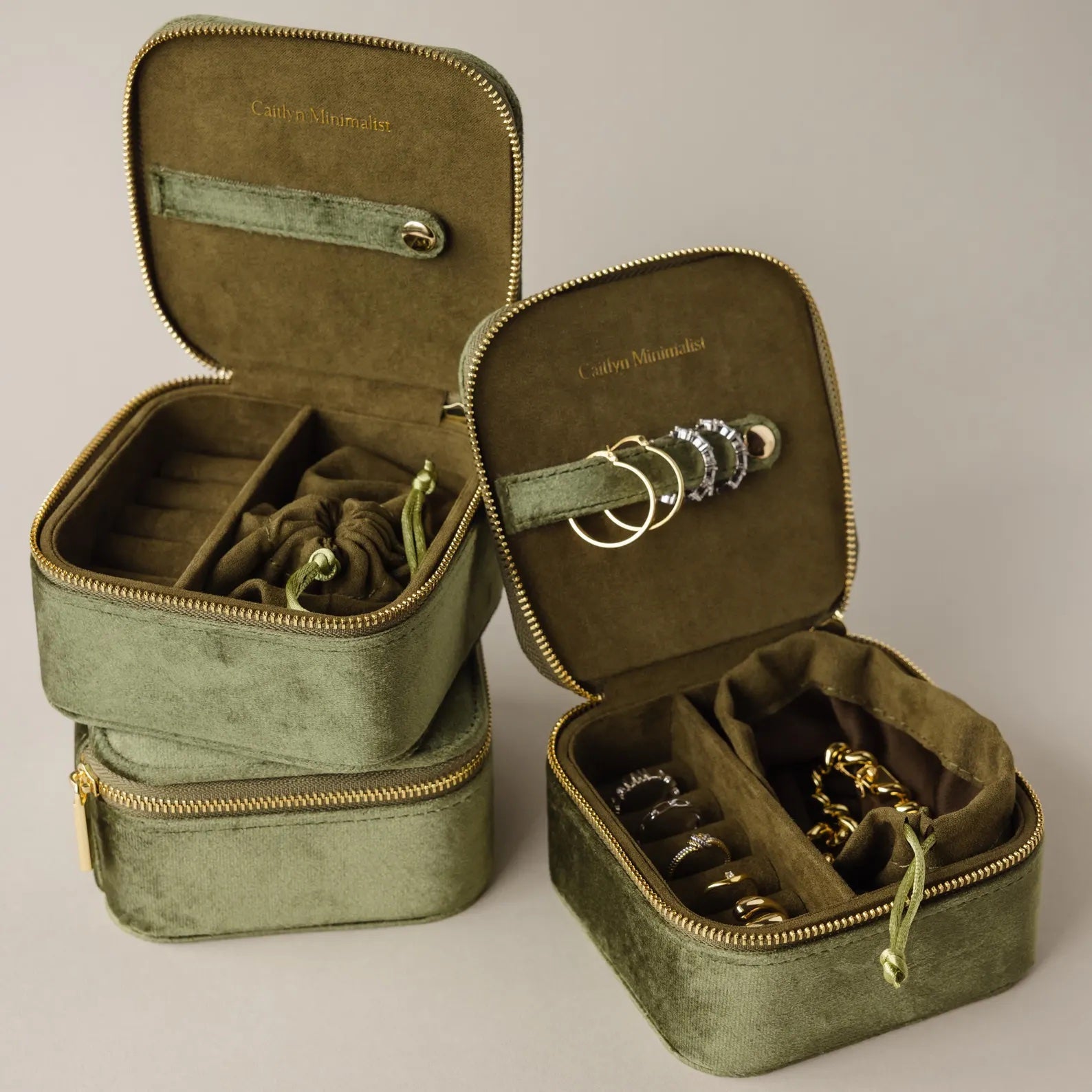 Two Green Velvet Jewelry Boxes, ideal for storage or travel, open to display organized rings, bracelets, and earrings inside.