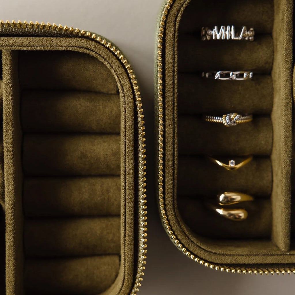 The Green Velvet Jewelry Box offers elegant storage, keeping gold and silver rings neatly organized in separate compartments.