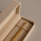 Gold bracelet with textured links displayed in the Bracelet Travel Case, a beige velvet jewelry holder, set on a neutral background.