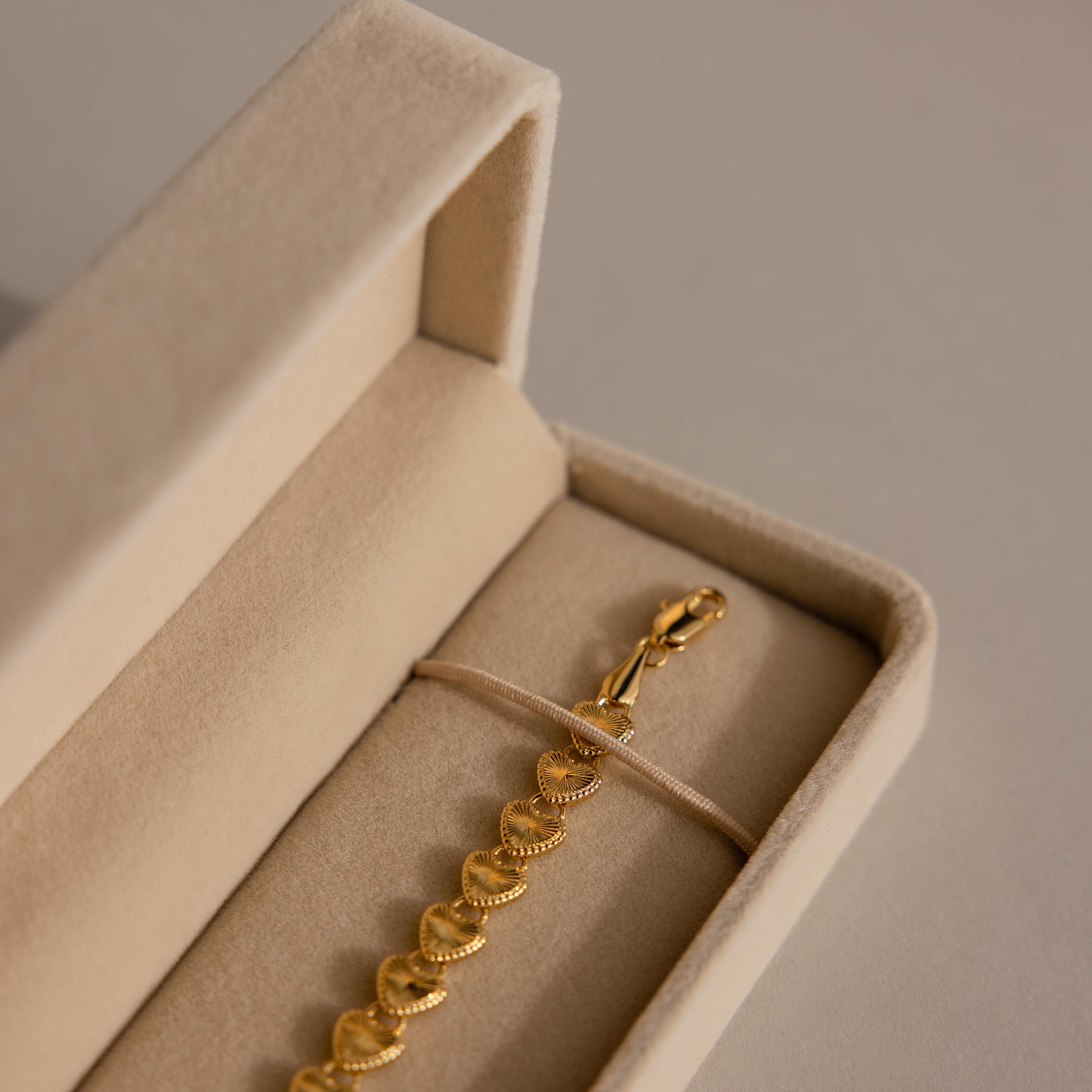 Gold bracelet with textured links displayed in the Bracelet Travel Case, a beige velvet jewelry holder, set on a neutral background.